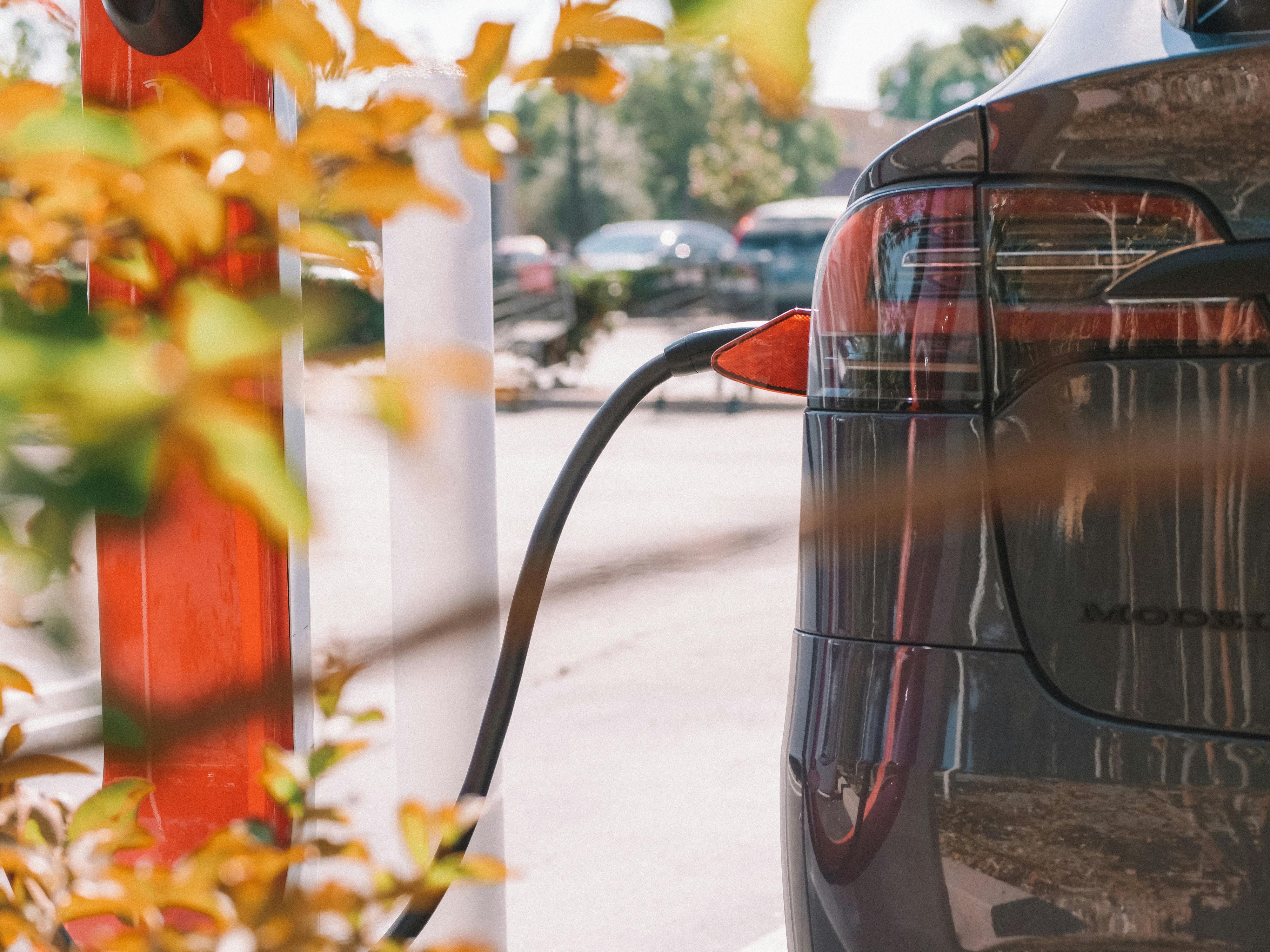 SUV électrique noir en charge sur une borne de recharge publique SUV électrique noir en charge sur une borne de recharge publique