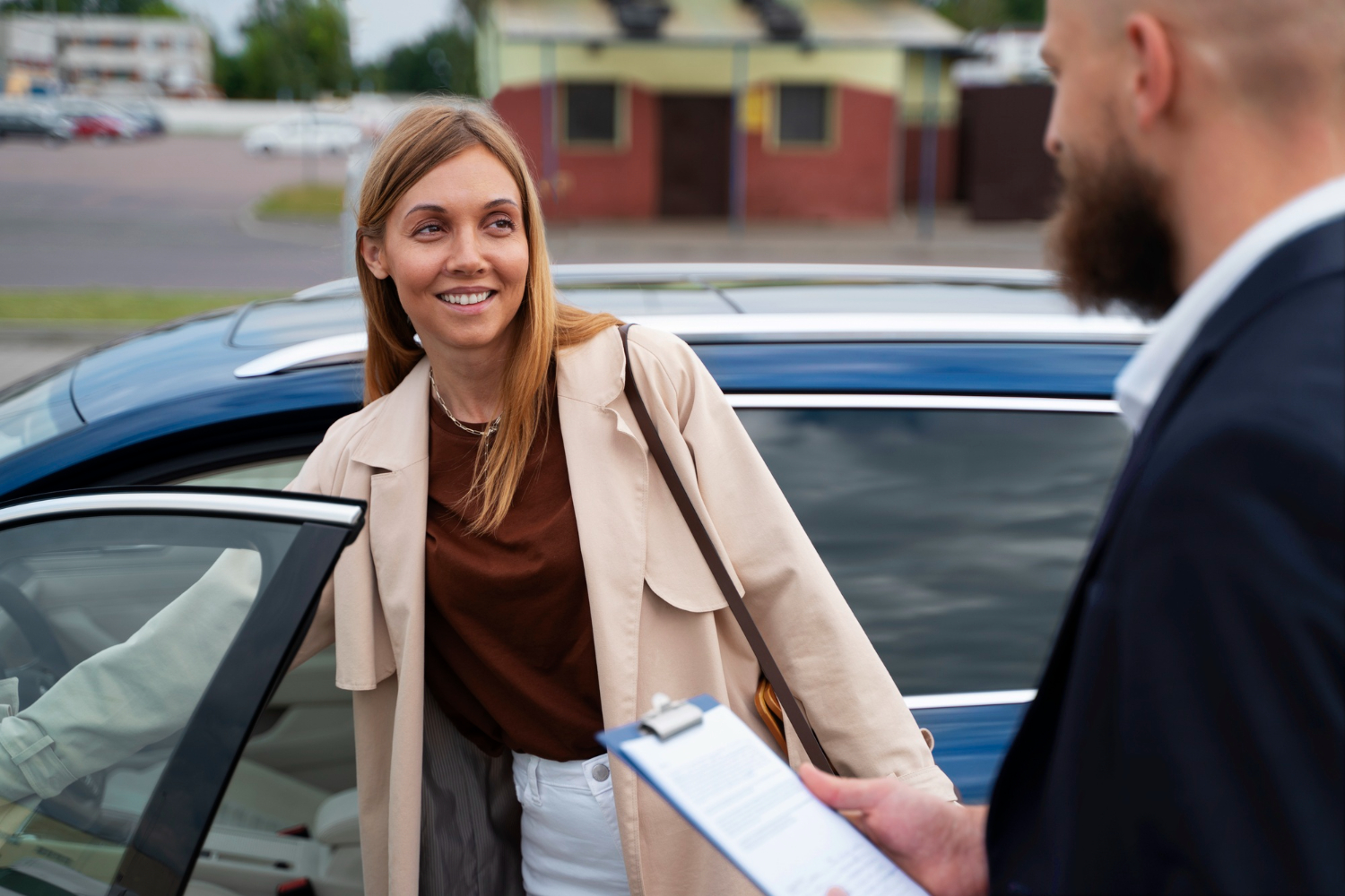 Femme et homme à côté d'une voiture parlant d'assurance Femme et homme à côté d'une voiture parlant d'assurance