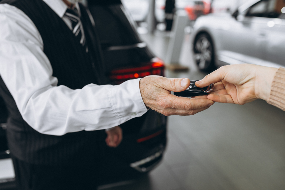 Homme recevant la clé d'une voiture de location